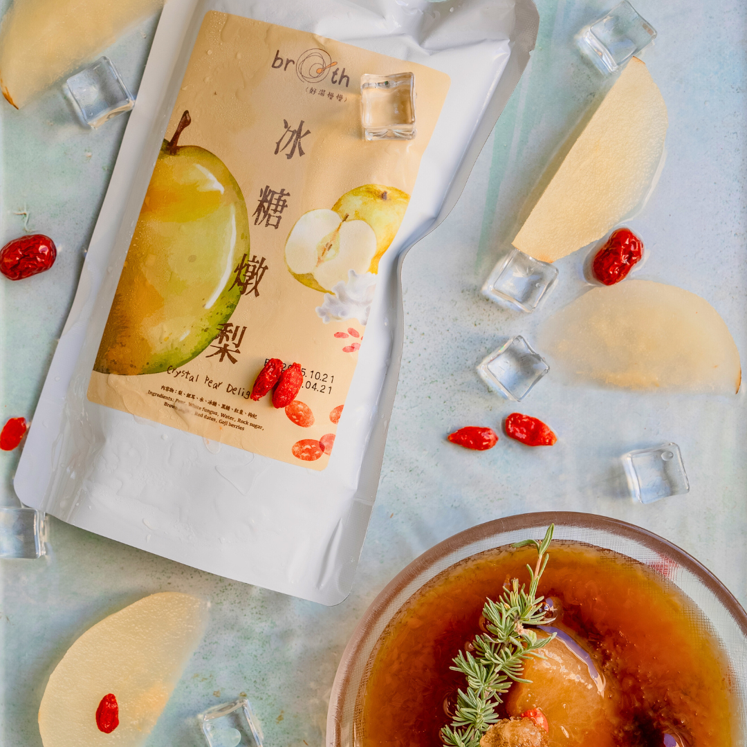 Packaged crystal pear with ice cubes and a bowl of tea on a light blue background