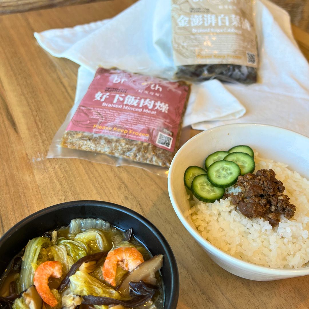 Two bowls of Braised Minced Pork & Braised Napa Cabbage a wooden table with packages of ingredients.