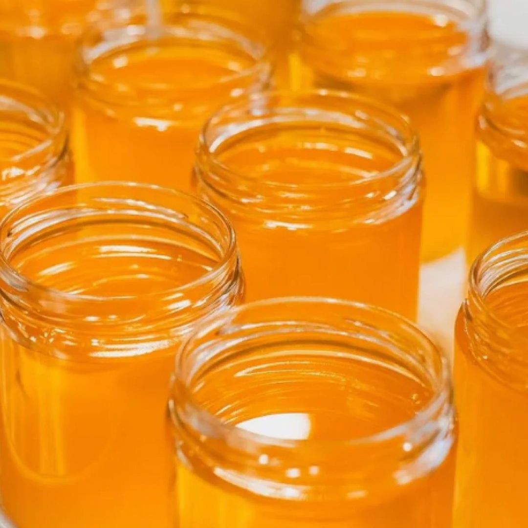 Close-up view of freshly filled glass jars of golden Sun Ghee – Pure Original clarified butter, highlighting the vibrant color and smooth texture of the product.