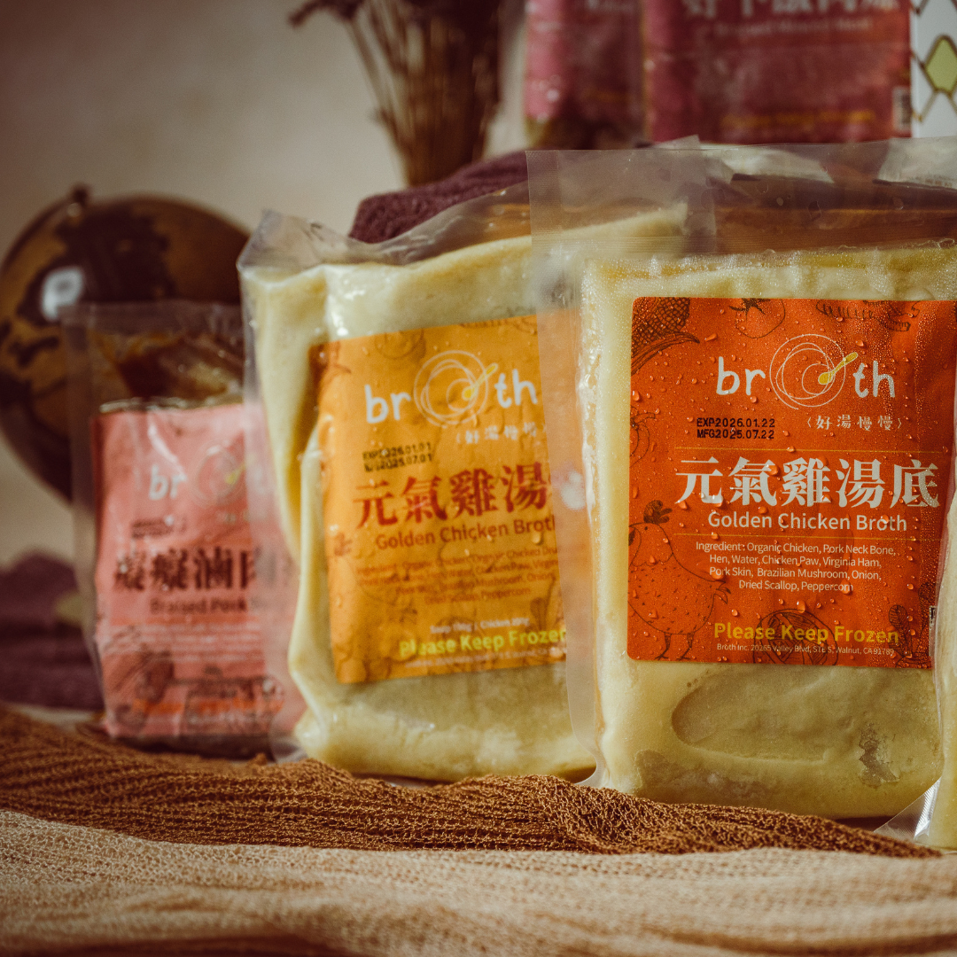 Packages of Golden Chicken broth with BROTH on a textured surface