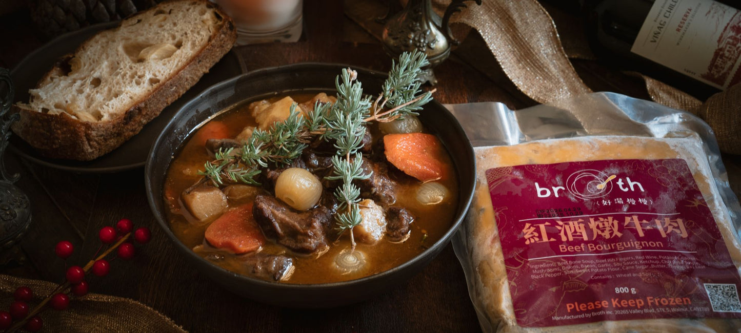 A rustic holiday-style banner featuring a bowl of Beef Bourguignon with tender beef, carrots, potatoes, and pearl onions in a rich stew, garnished with fresh herbs. Beside it sits a slice of artisan bread and the product’s frozen packaging labeled “好湯慢慢 Beef Bourguignon,” all arranged with warm candlelight, red berries, and wine for a cozy festive mood.