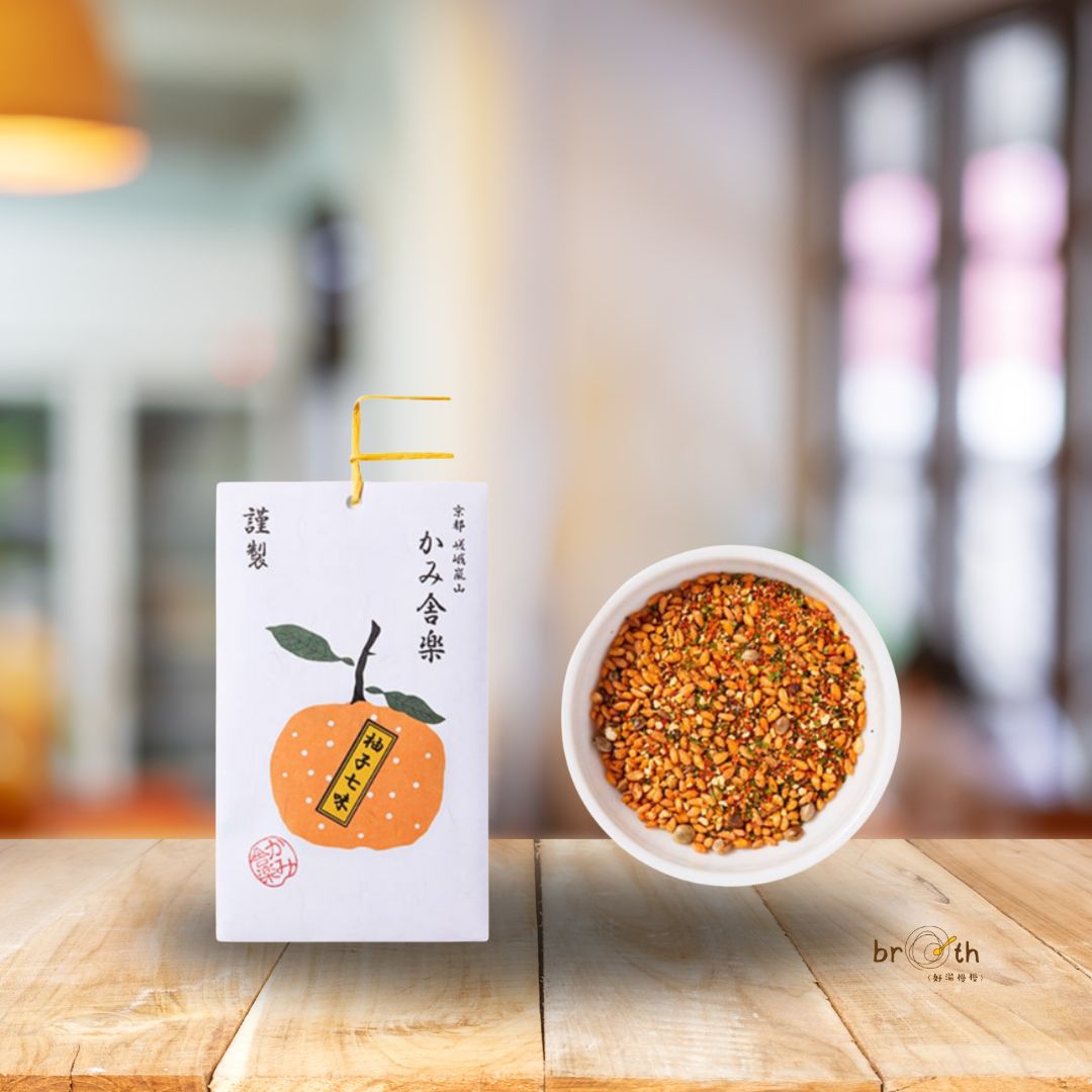 Kamisharaku Yuzu Shichimi packaging with orange yuzu illustration, placed beside a bowl of colorful seven-spice blend — handcrafted in Kyoto, Japan.
