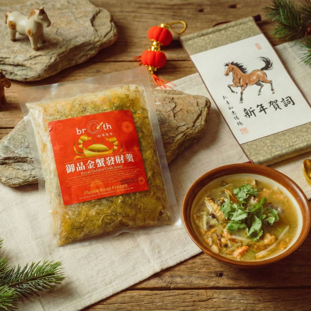 A flat-lay of the frozen 【Limited Edition】Royal Golden Crab Soup package on a festive gold background with red berries, traditional decorations, and a bowl of crab soup, highlighting the seasonal limited-edition packaging.