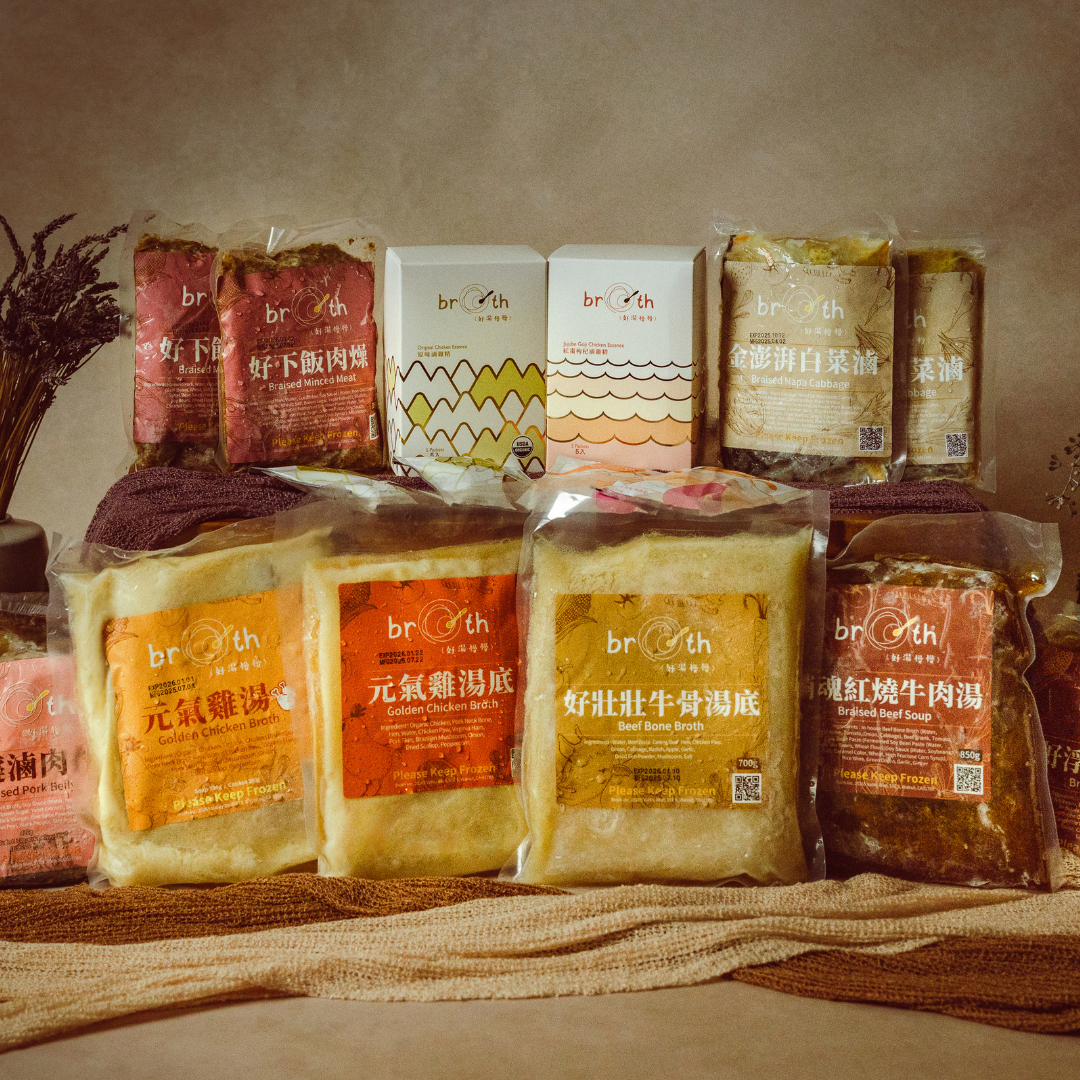 Assorted packages of broth products on a textured surface with a neutral background