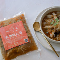 Frozen BROTH Imperial Squid Plant-Based Shark Fin Soup package shown beside a prepared bowl of soup with plant-based fin, squid paste pieces, cilantro, and a gold spoon.