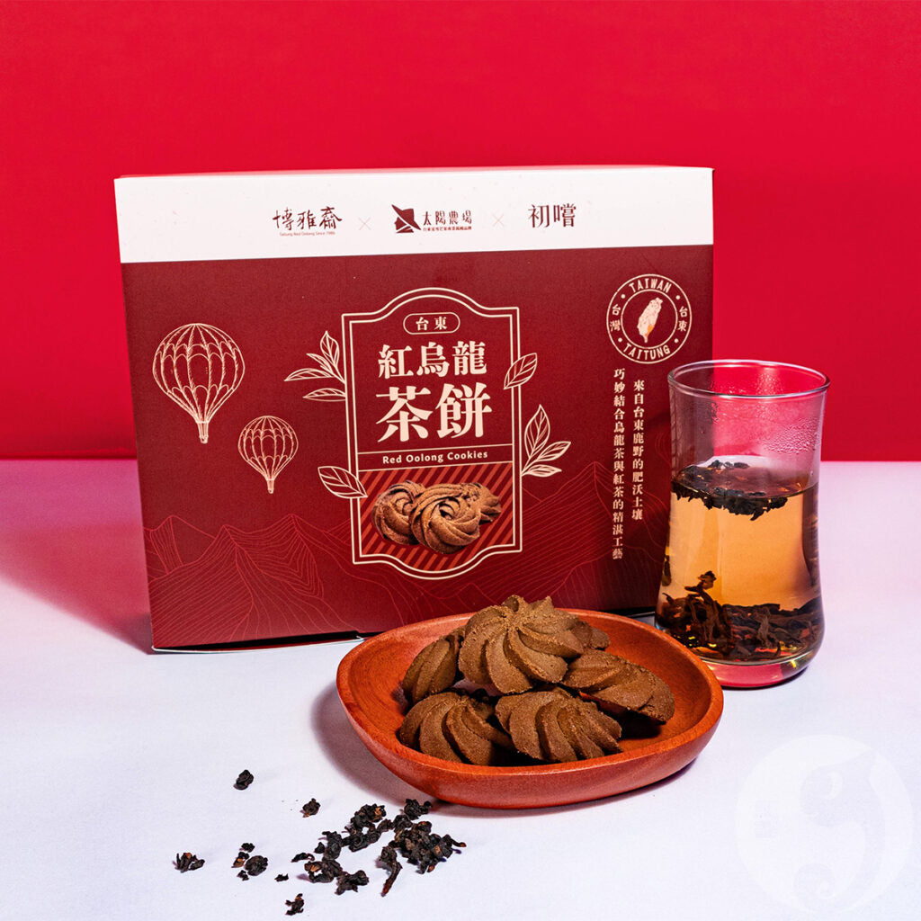 Red packaging of Red Oolong Tea Cookies with a glass of tea and cookies on a red background